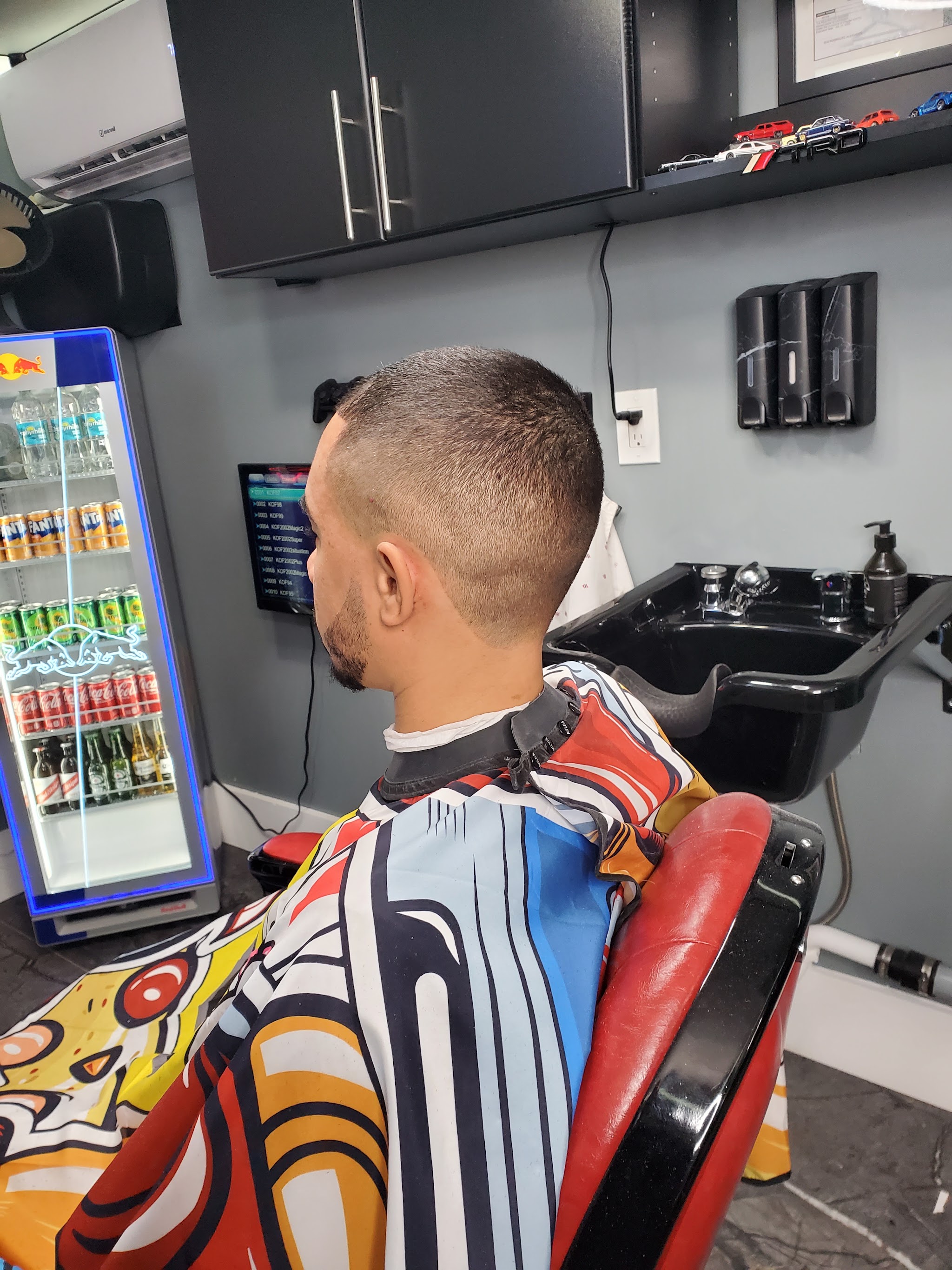 Client in the chair getting a skin fade beside the wash station
