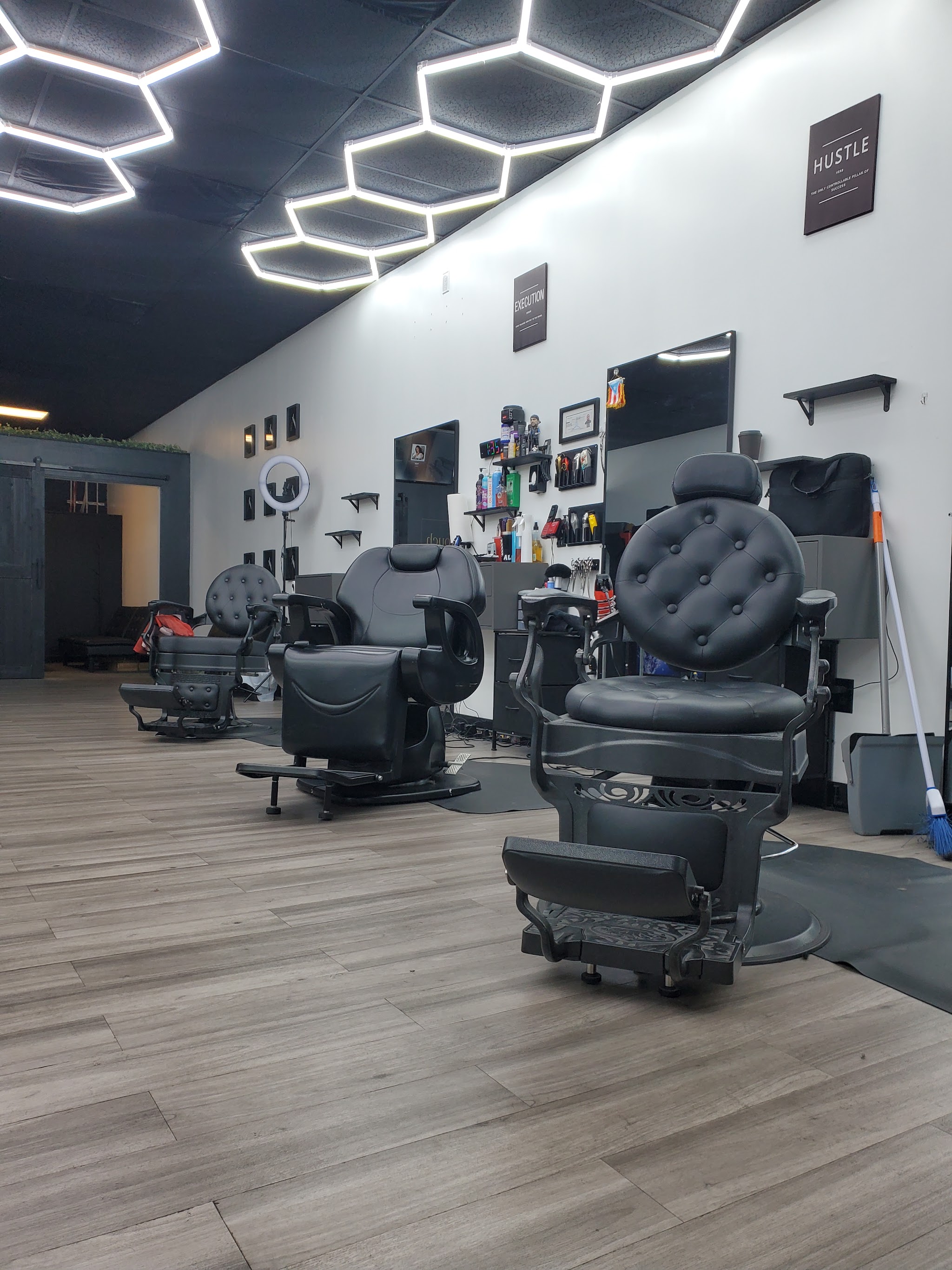 Inside the shop: leather barber chairs under hexagon lights
